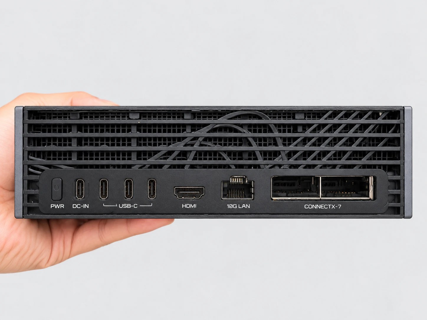 Rückseite der in der Hand gehaltenen AI TOP ATOM: PWR-Taste, DC-IN-Eingang über USB-C, drei USB-C-Anschlüsse, ein HDMI-Ausgang, ein 10G-LAN-Anschluss und die beiden QSFP-Anschlüsse der ConnectX-7-Karte.